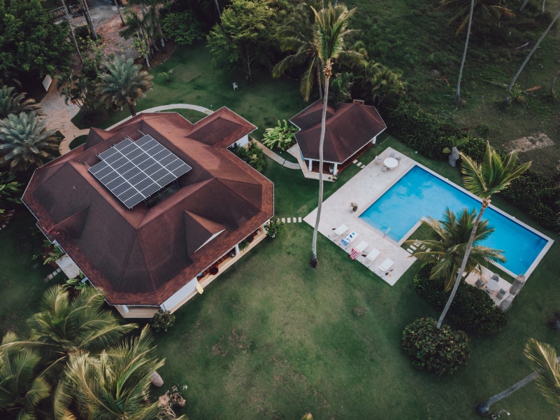 Aerial drone view of luxury villa with the pool and solar panels on the roof