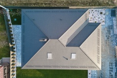 Aerial view of house roof top covered with ceramic shingles. Tiled covering of building under construction